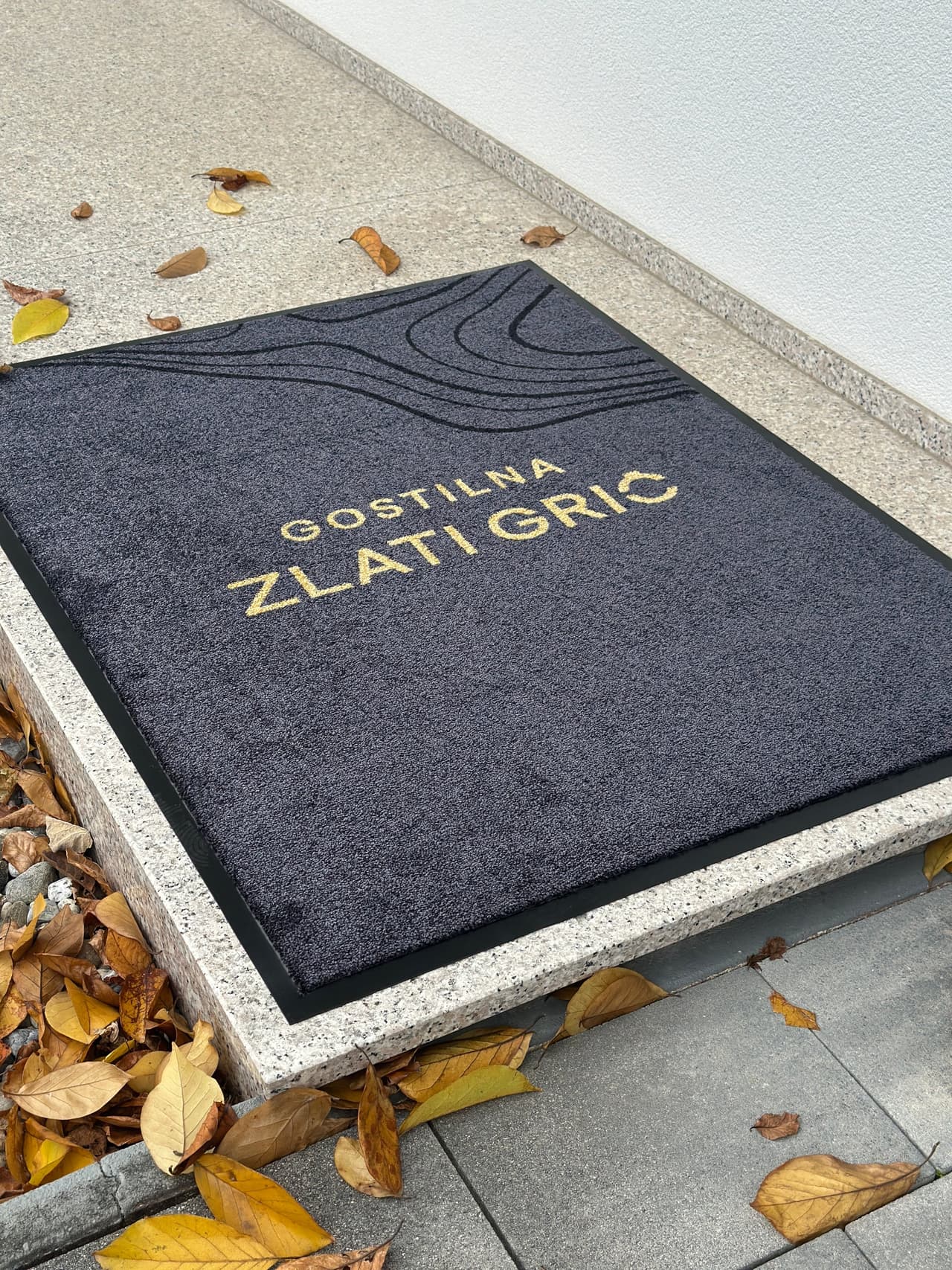Predpražnik z logotipom in tiskom.